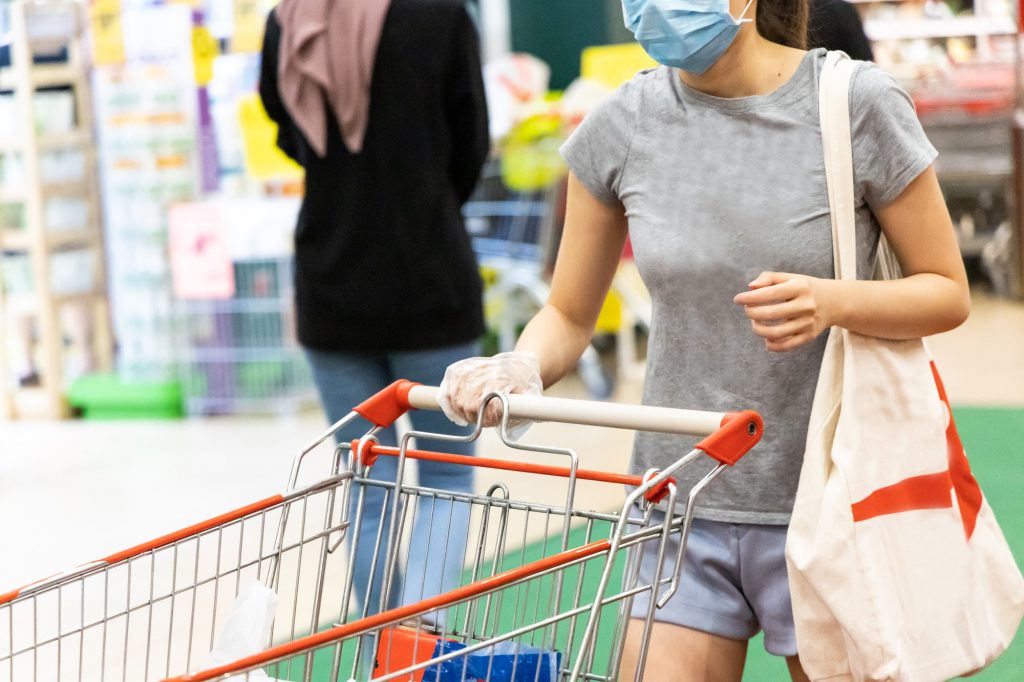 New normal lifestyle with shoppers put on disposable gloves in supermarket