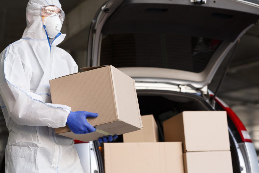 Man in coronavirus suit delivering goods, products and medicine