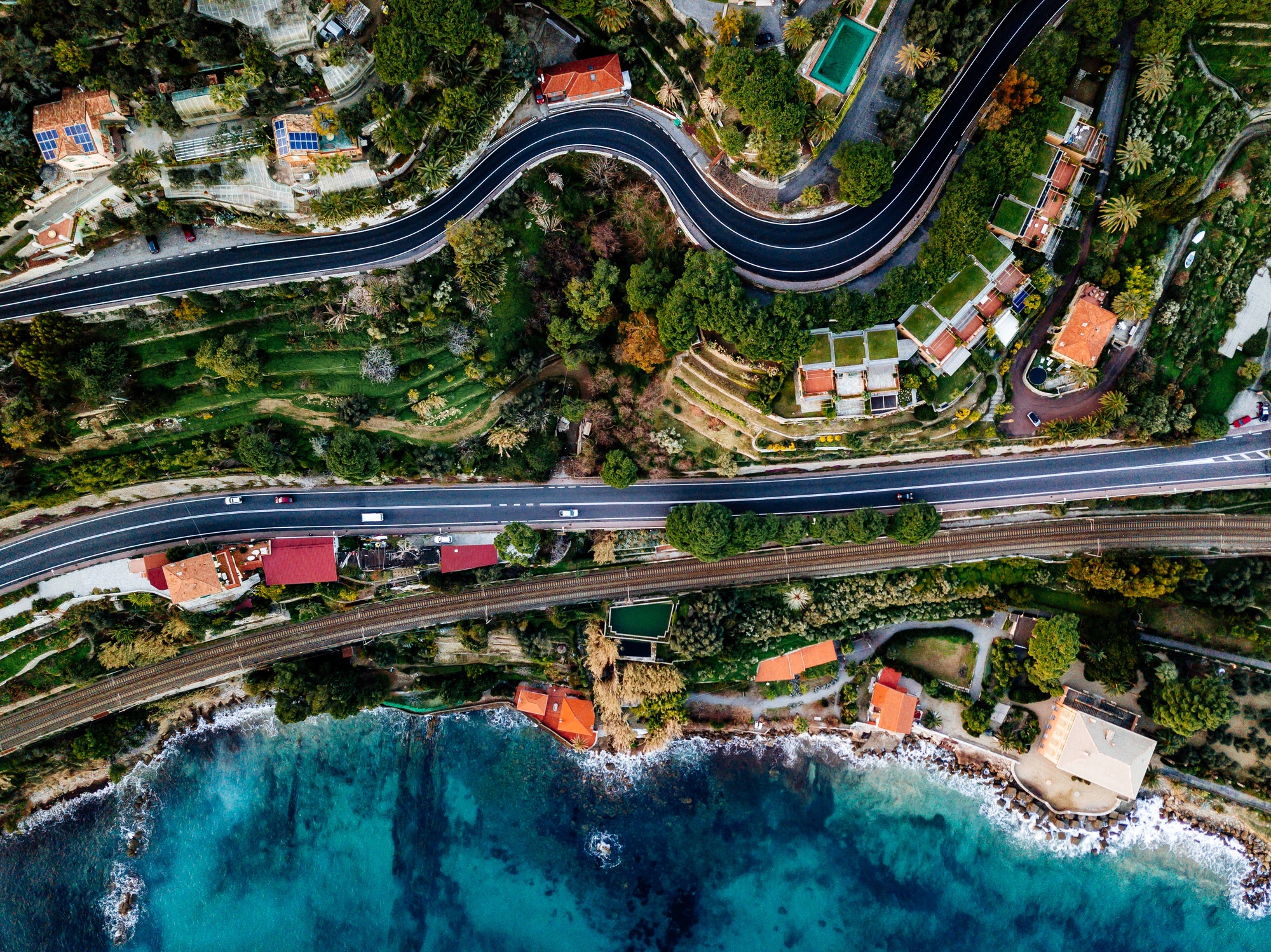 Aerial view of road, highway and railway going along ocean or sea. Drone photography in rural Italy