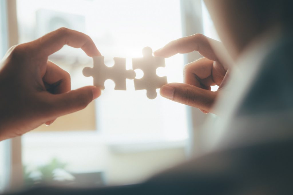 Businessman hand connecting jigsaw puzzle.