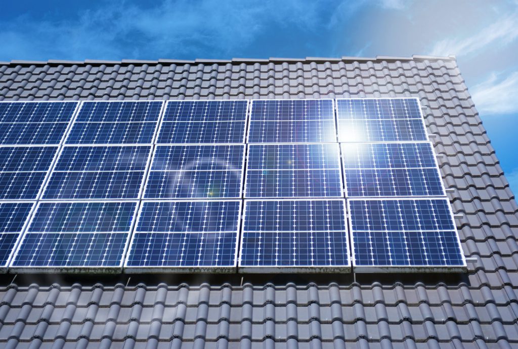 Roof photovoltaic panels under cloudy blue sky