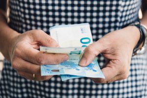 Hand of woman with stack of euros.