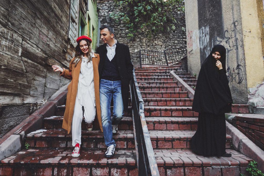 European couple walking at old istanbul streets in Balat. local women are veiled in paranja