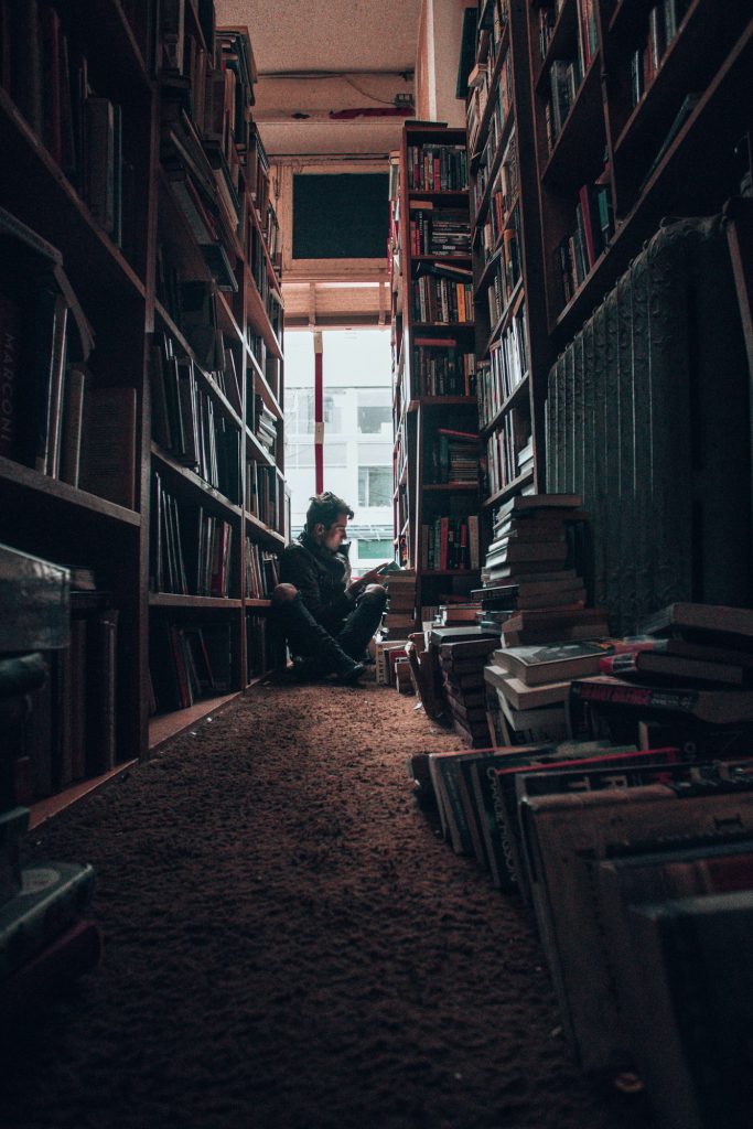 Reading between overflowing bookshelves