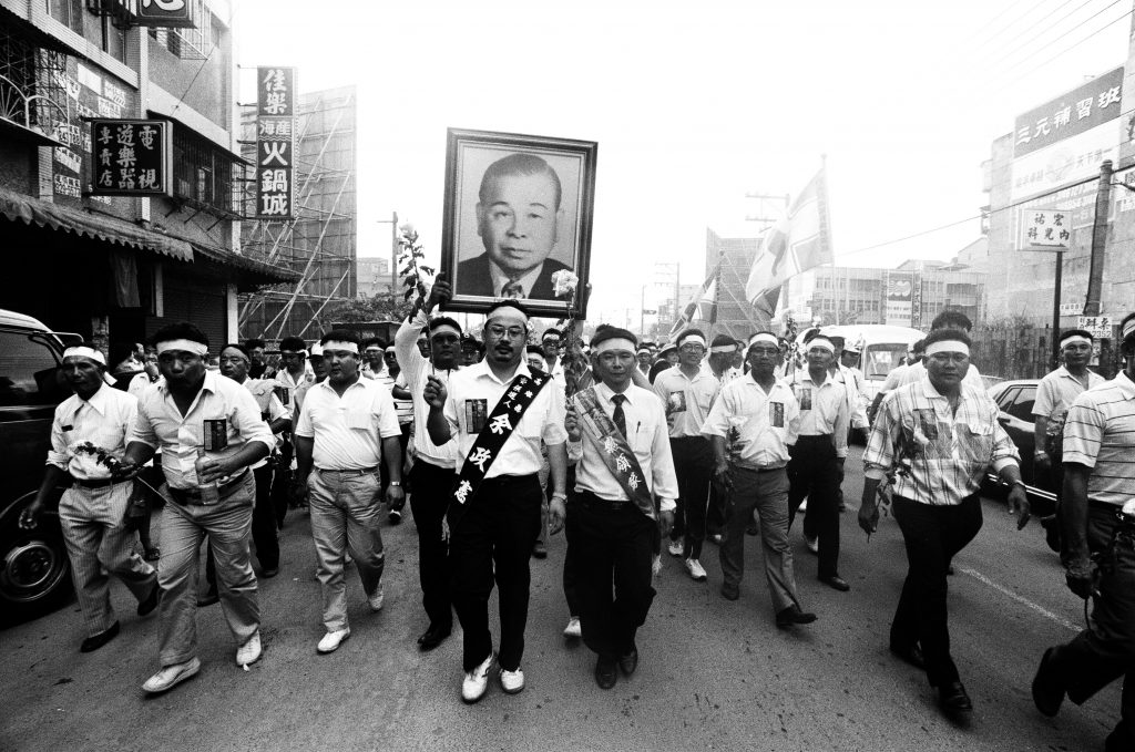 1989 年 10 月 10 日下午 2 點，民進黨發起「迎接許信良回家」活動。余政憲立委舉著前高雄縣長余登發的遺像，劉文福帶領鄉親走在隊伍前面。／圖：邱萬興提供