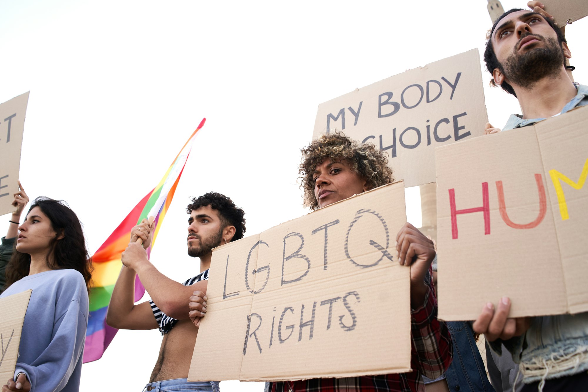 Crowd raising rainbow symbols and banners for LGBT rights.