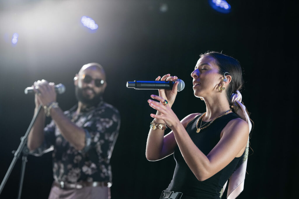 The Shure SLX-D wireless system in use by a female singer with a male singer in the background