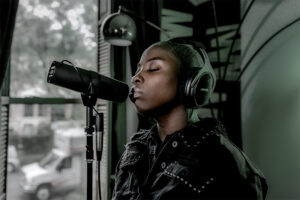 A female singer using the Shure SM7B microphone in the studio, wearing headphones 