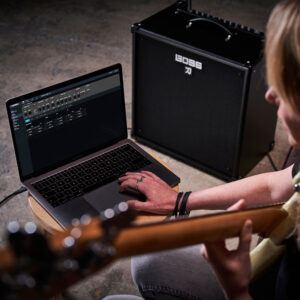 A bassist using the Katana Bass Tone Central on a laptop