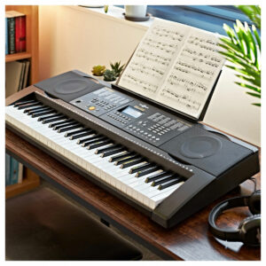 MK-6000 Keyboard with USB MIDI by Gear4musicon a wooden desk with headphones and sheet music, surrounded by books and plants