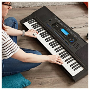 Woman sat on the floor playing the VISIONKEY-20 Keyboard by Gear4music