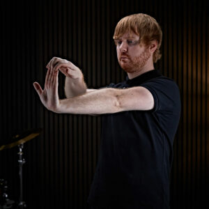 A drummer stretching his fingers in preparation for drumming