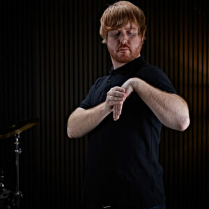 A drummer warming up his wrist before drumming