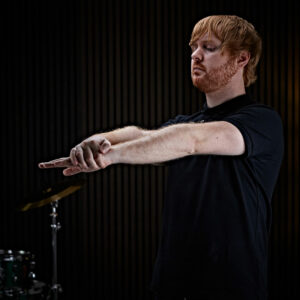 A man stretching his fingers before drumming