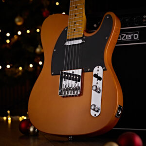 The Knoxville Electric Guitar by Gear4music, Butterscotch stood against a Subzero amp, surrounded by Christmas lights and baubles