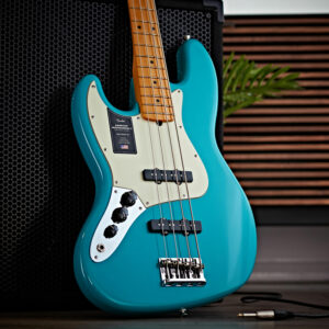 Fender American Pro II Jazz Bass MN LH, Miami Blue leant against an amp