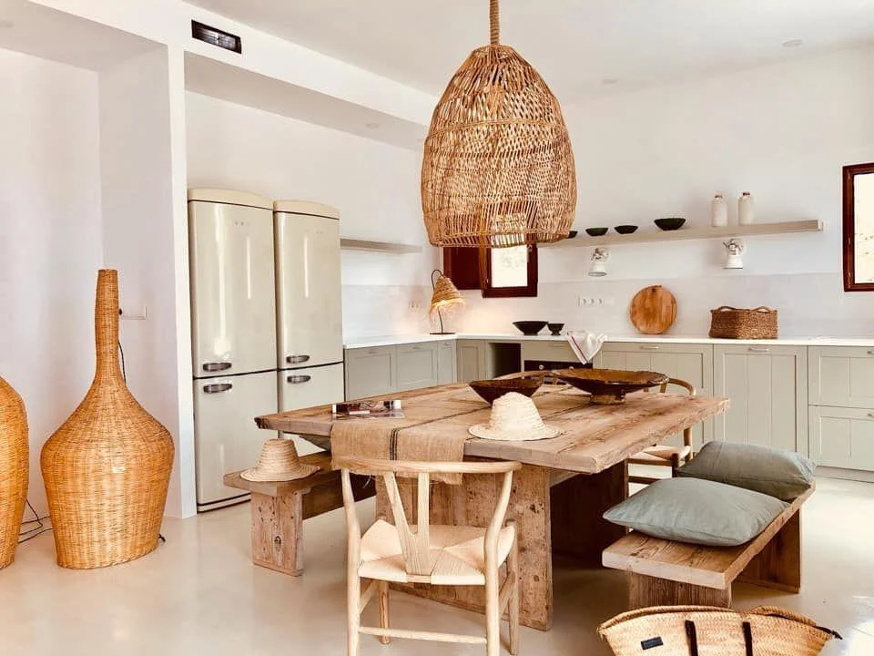 Fabulous open concept kitchen in Cala Saona, Formentera, featuring corner cabinets, a double fridge and a solid wood island.