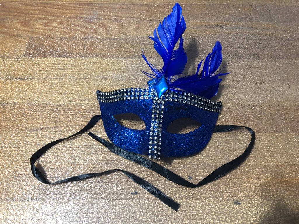 Blue half mask (covers eyes and top of nose). Royal blue colour with silver "gems" in 3 rows along brow line and bridge of nose. Royal blue feathers fastened with a blue "gem"