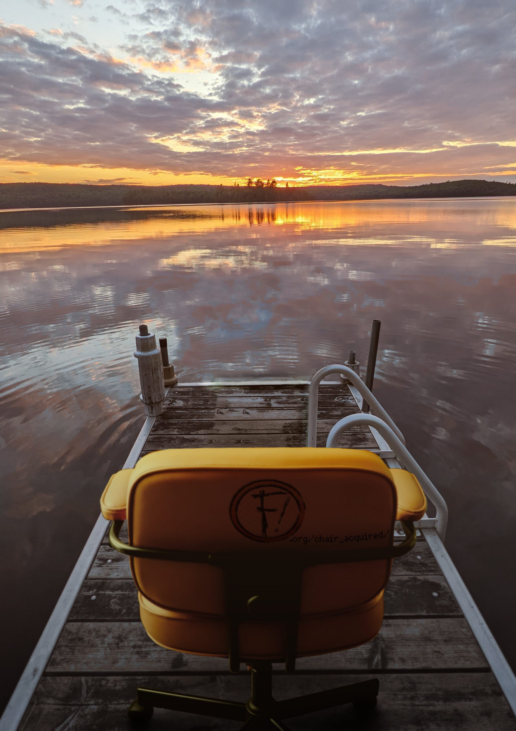 Picture of an office chair on a dock overlooking a sunset. You find a URL hidden on the back of the chair.