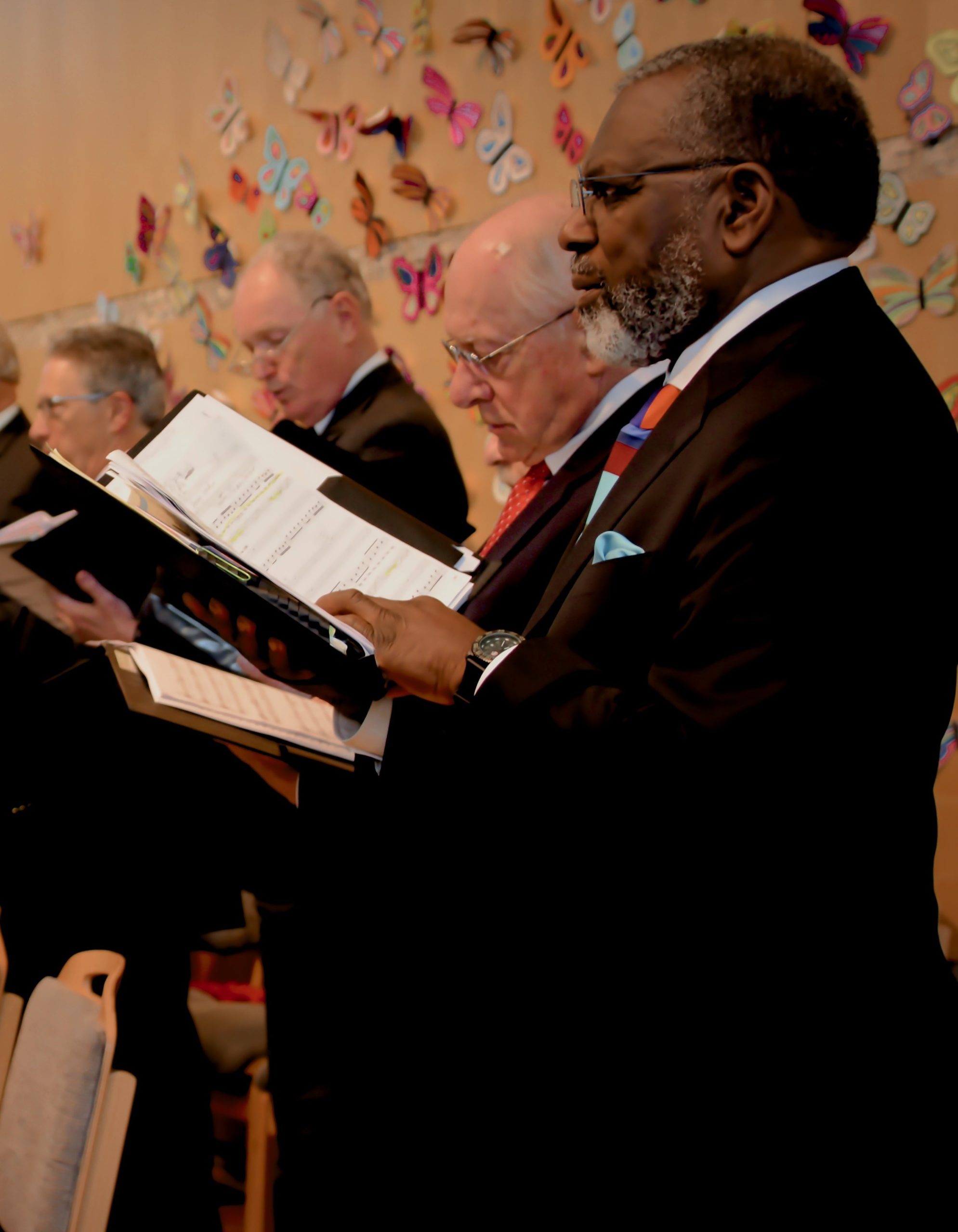 Man stands in choir looking at sheet music