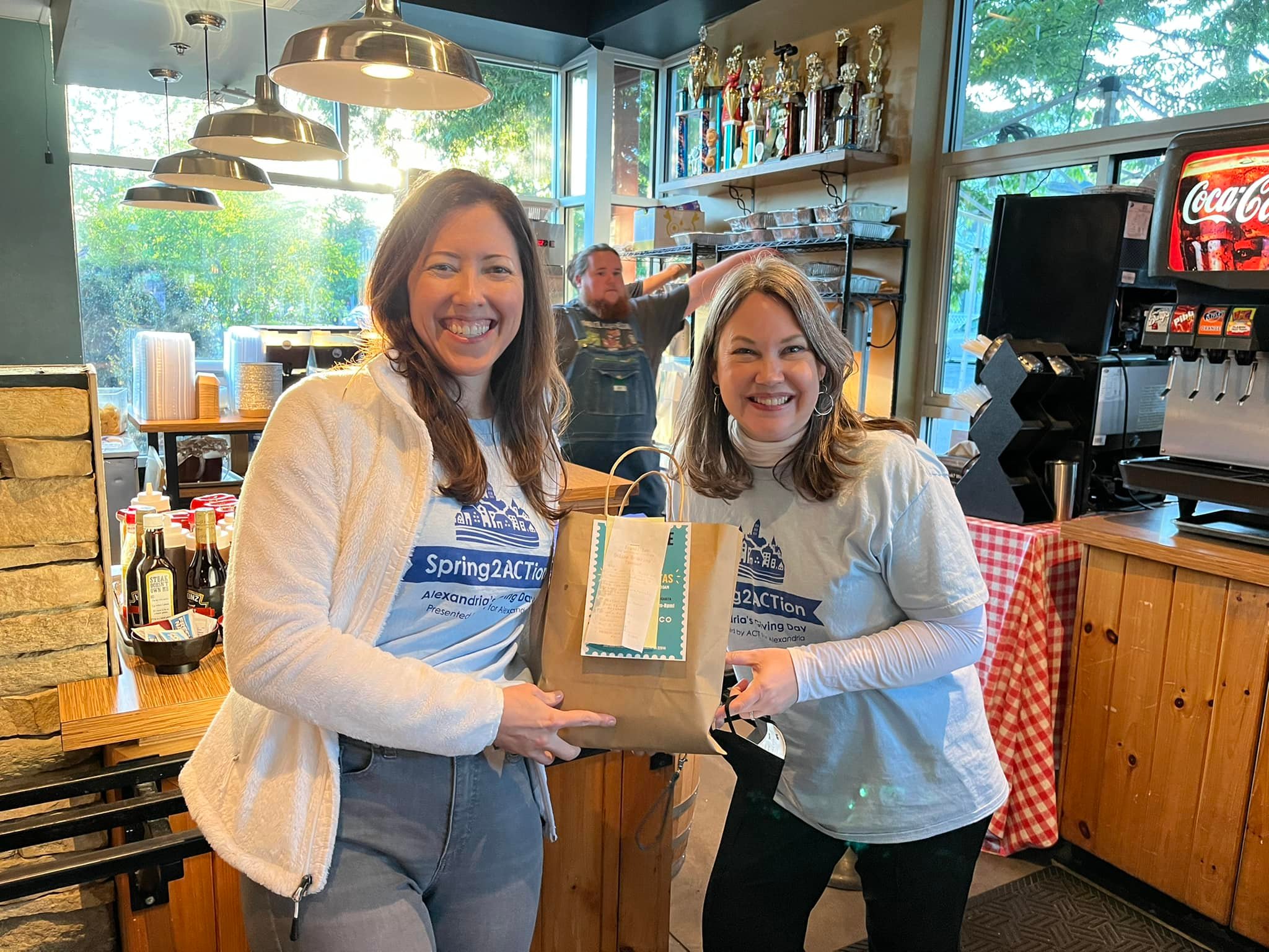 two women in coffee shop holding paper bag