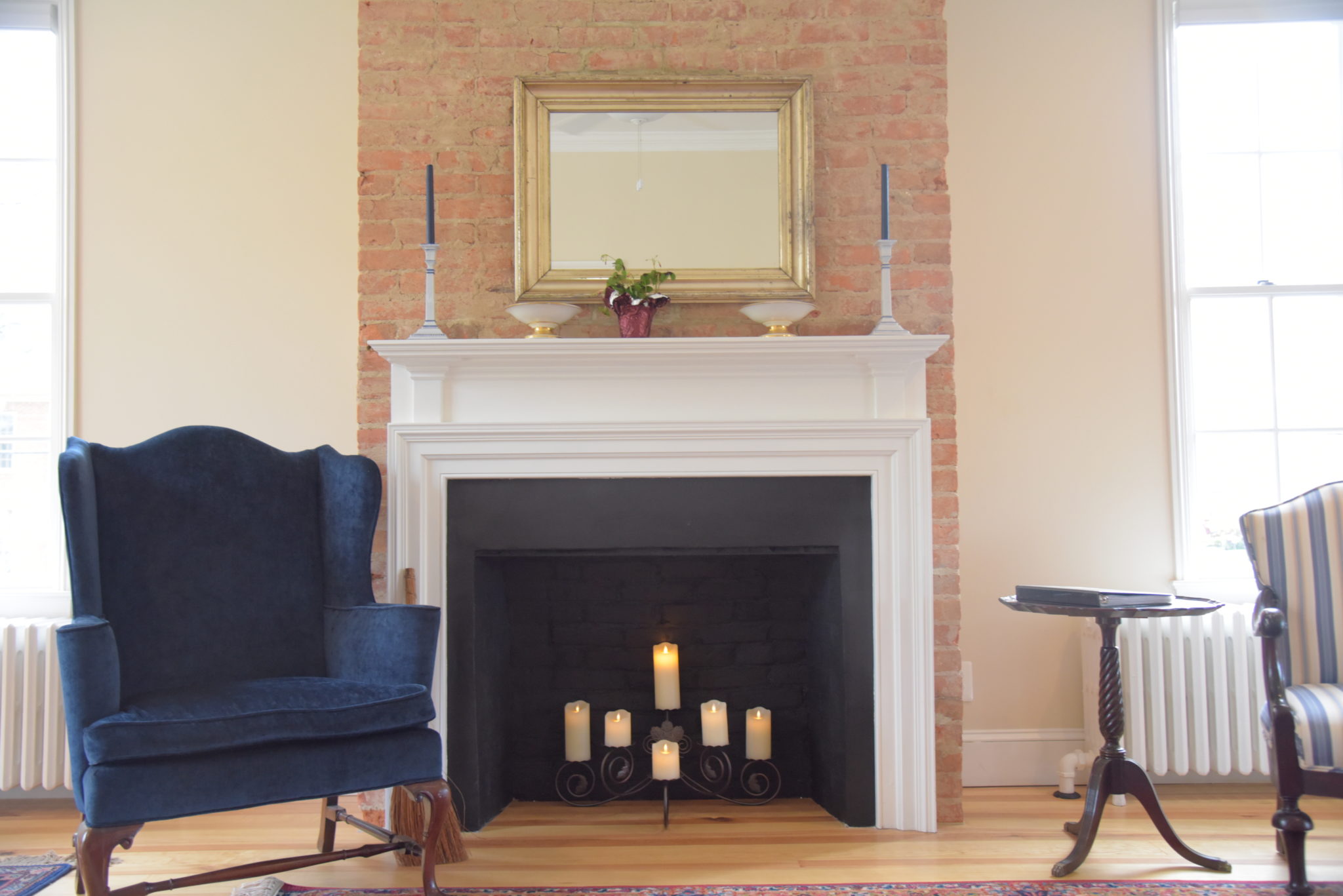 A brick fireplace surrounded by antique furniture