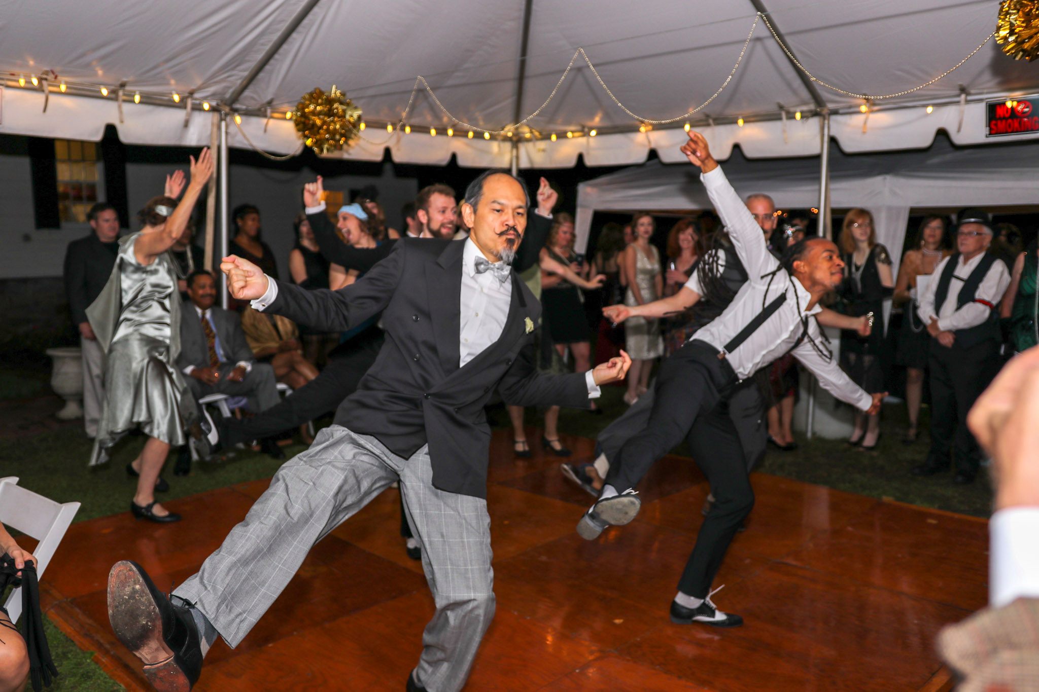 two men in tuxedos and suspenders on dance floor