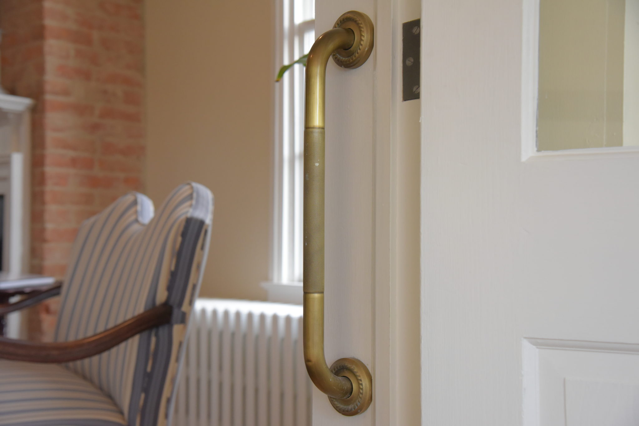 a brass grab bar installed in a doorway