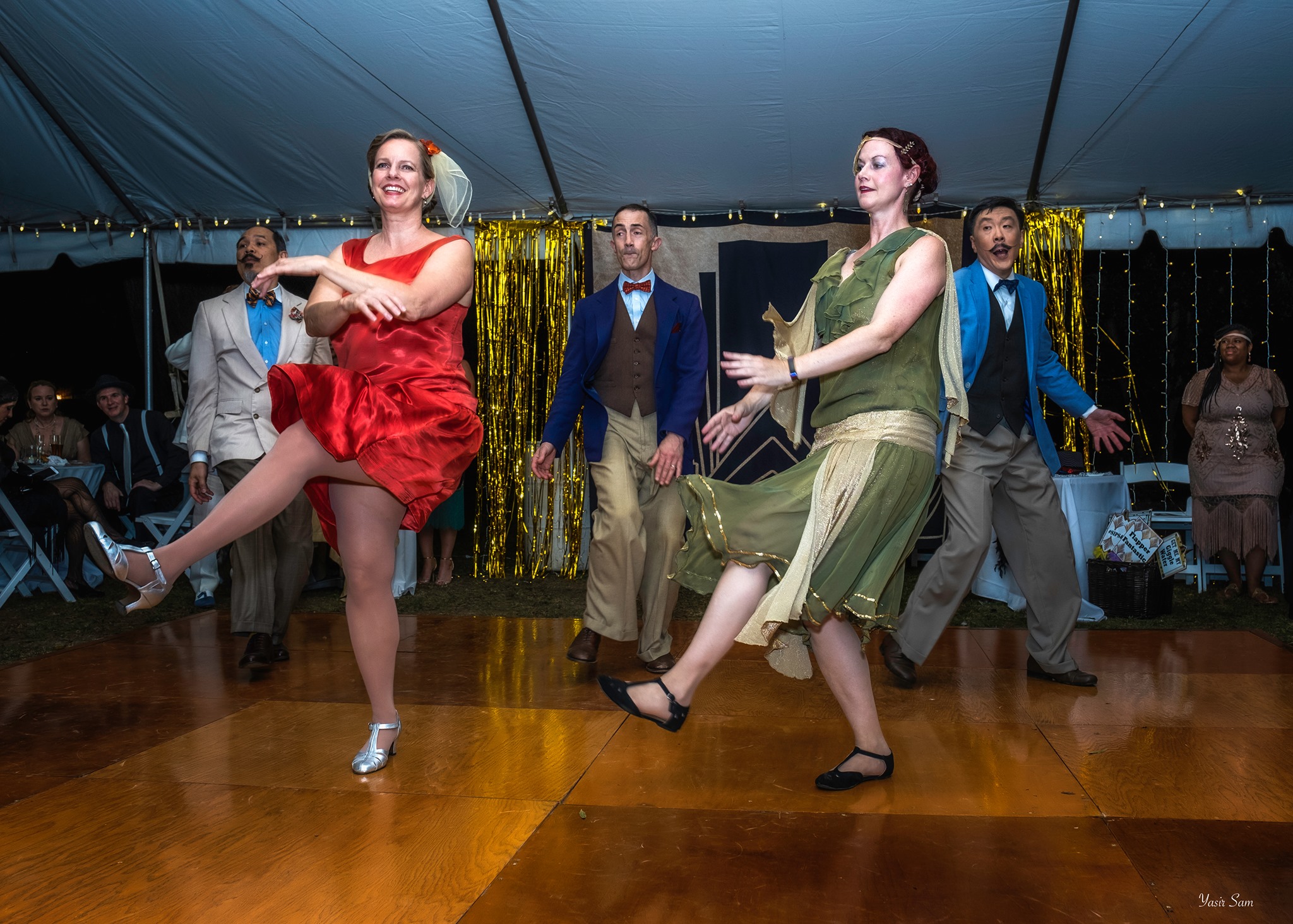 two women in flapper dresses doing the Charleston dance