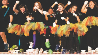 youth students in rainbow tutus dance on stage