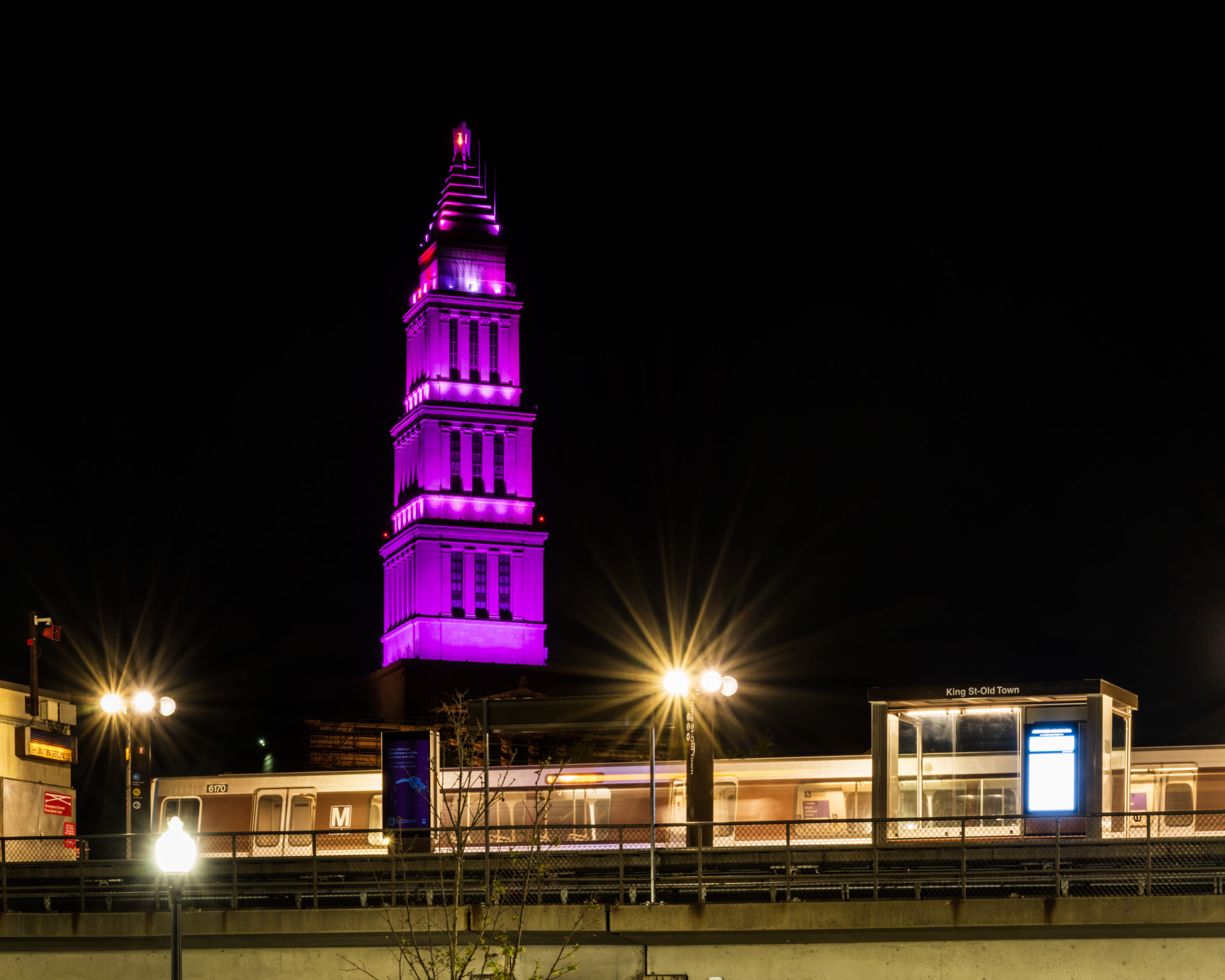 building behind a train illuminated in purple