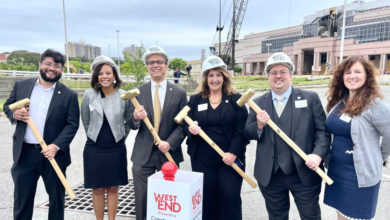 alexandria city council members stand with hard hats and hammers