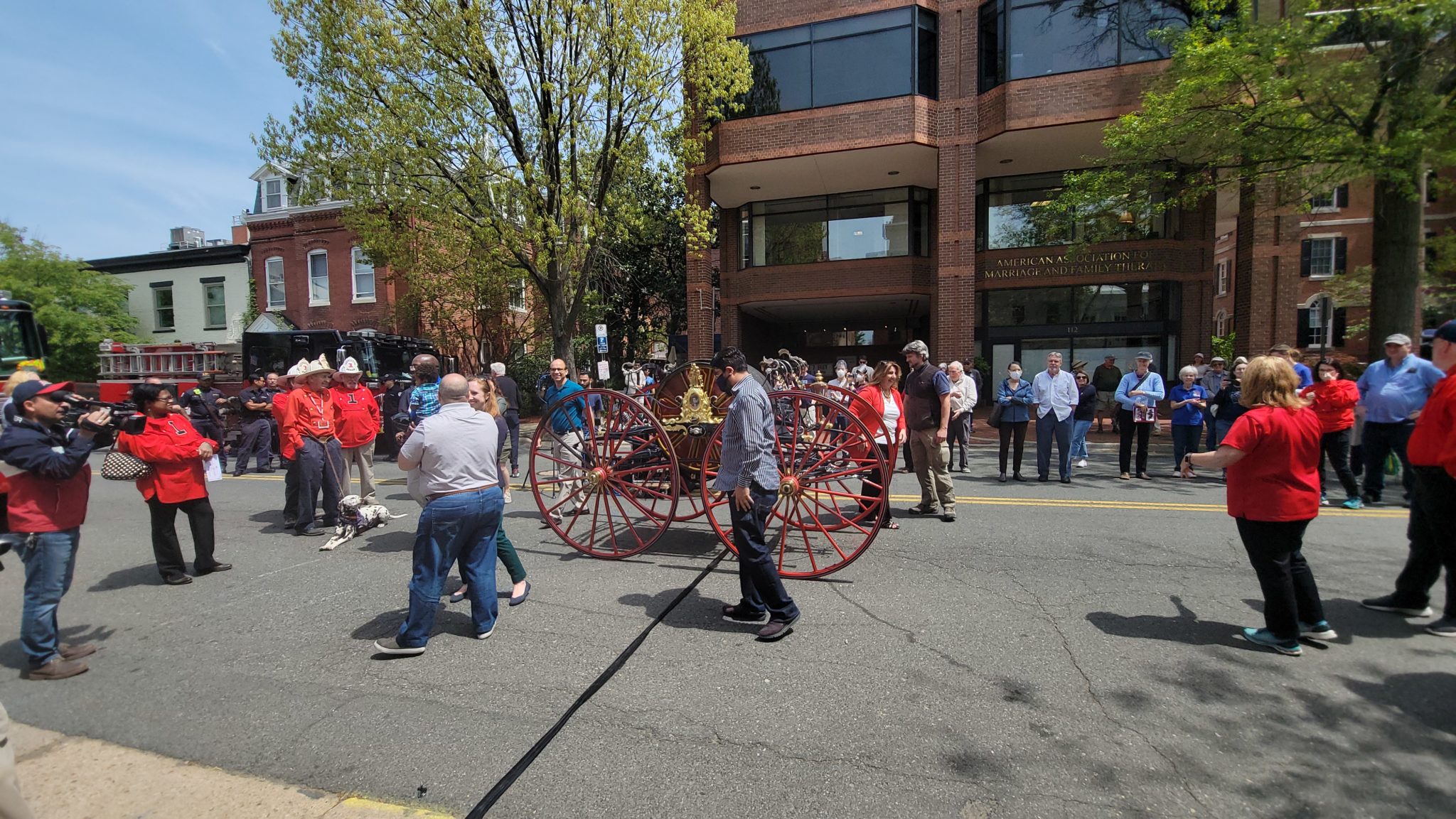 group of people standing in street with carriage