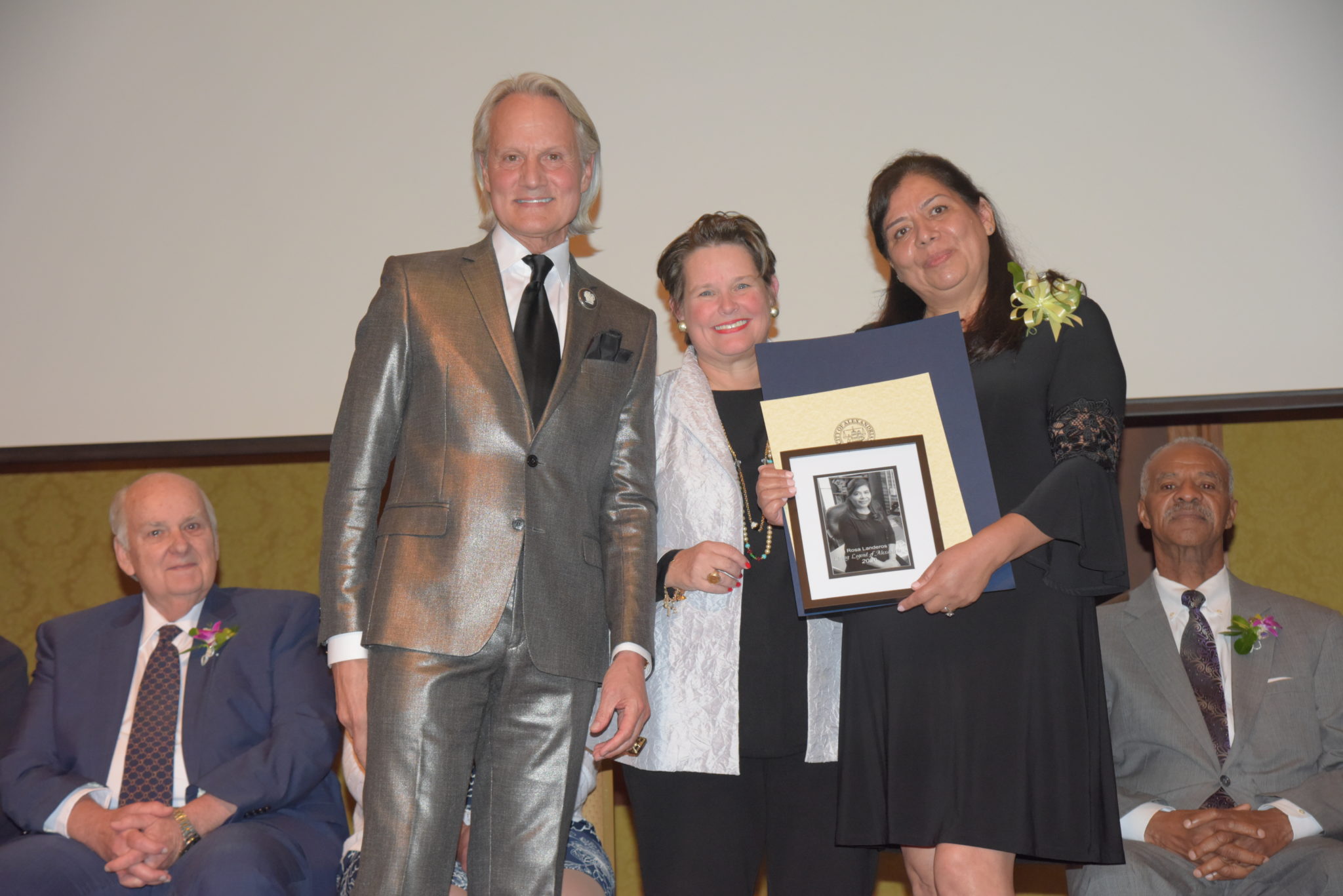 Rosa Landeros holds photo and certificates and stands next to Mary Wadland and Monte Durham