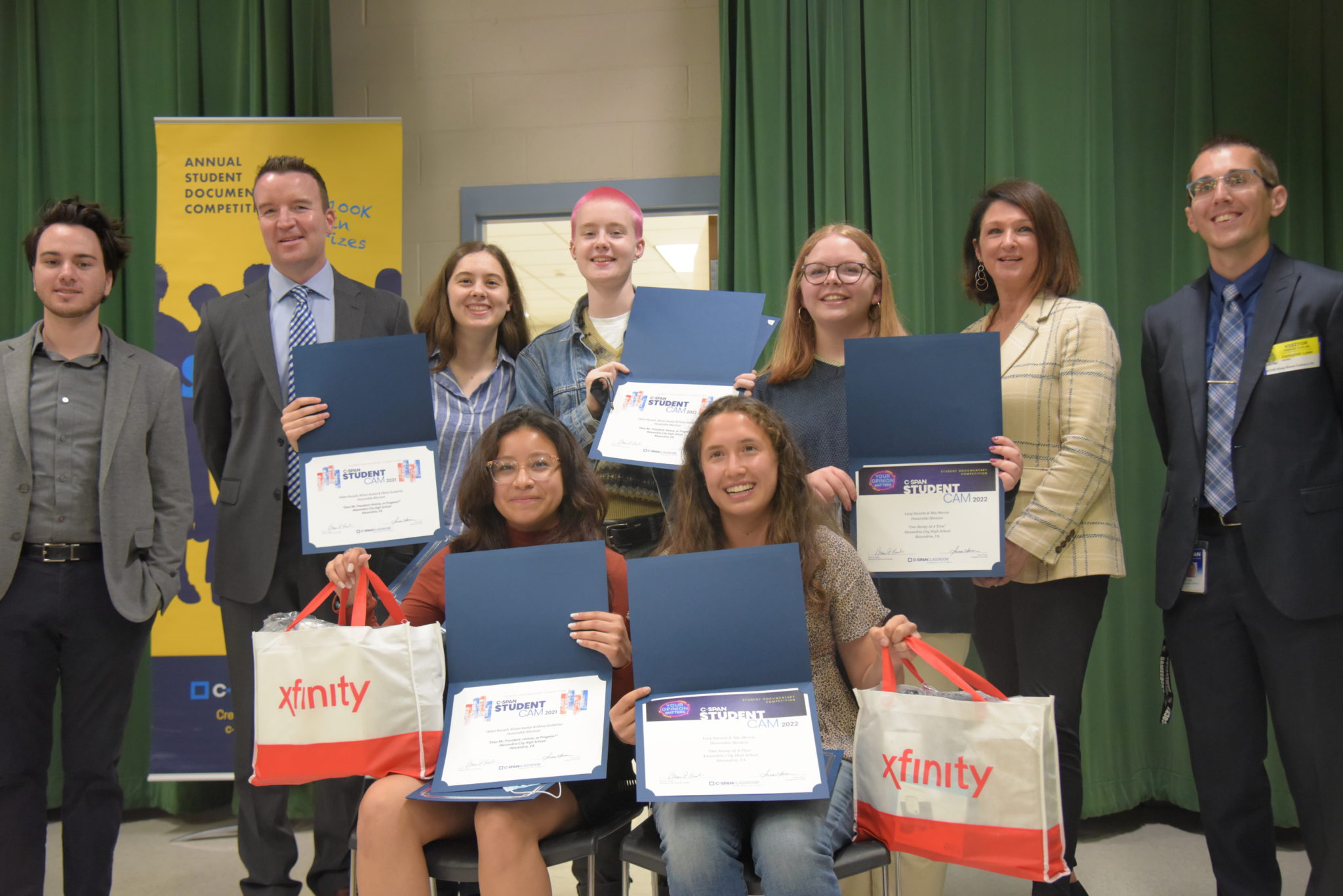 high school girls pose with adults holding up winners certificates