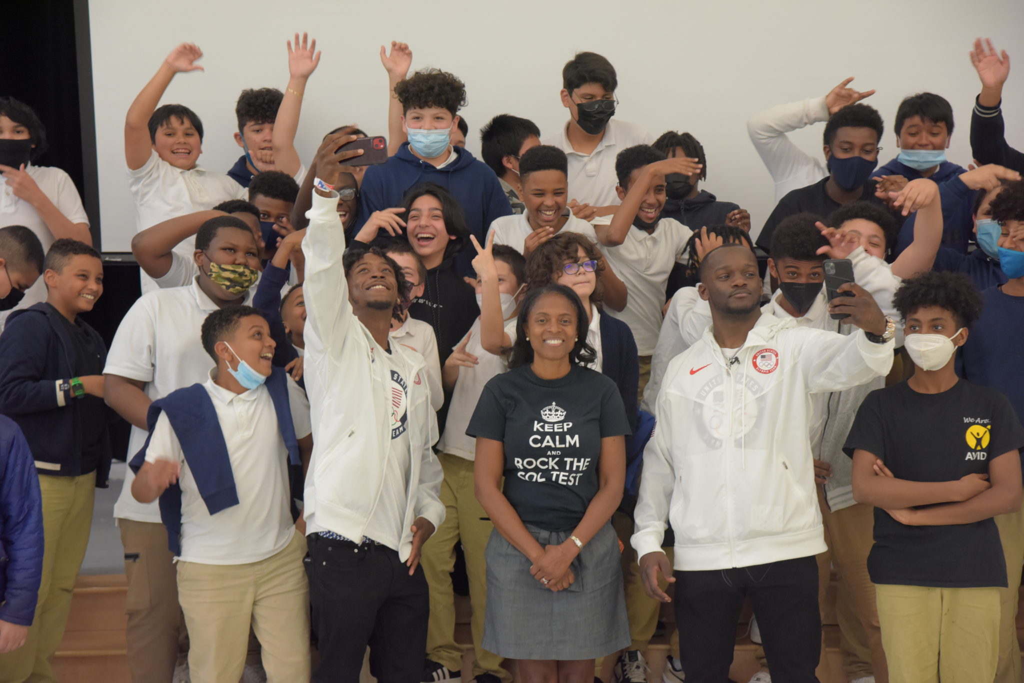 male middle school students take selfie with male olympic boxers