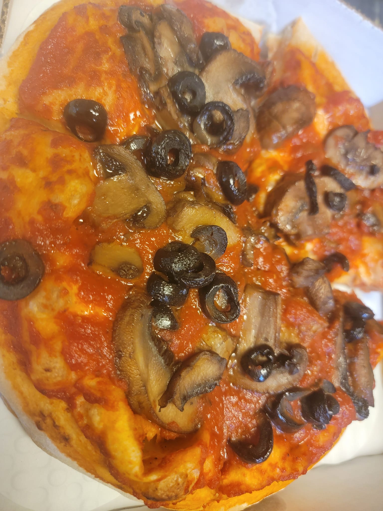 a pizza with vegan cheese, black olive, mushroom from Wegmans