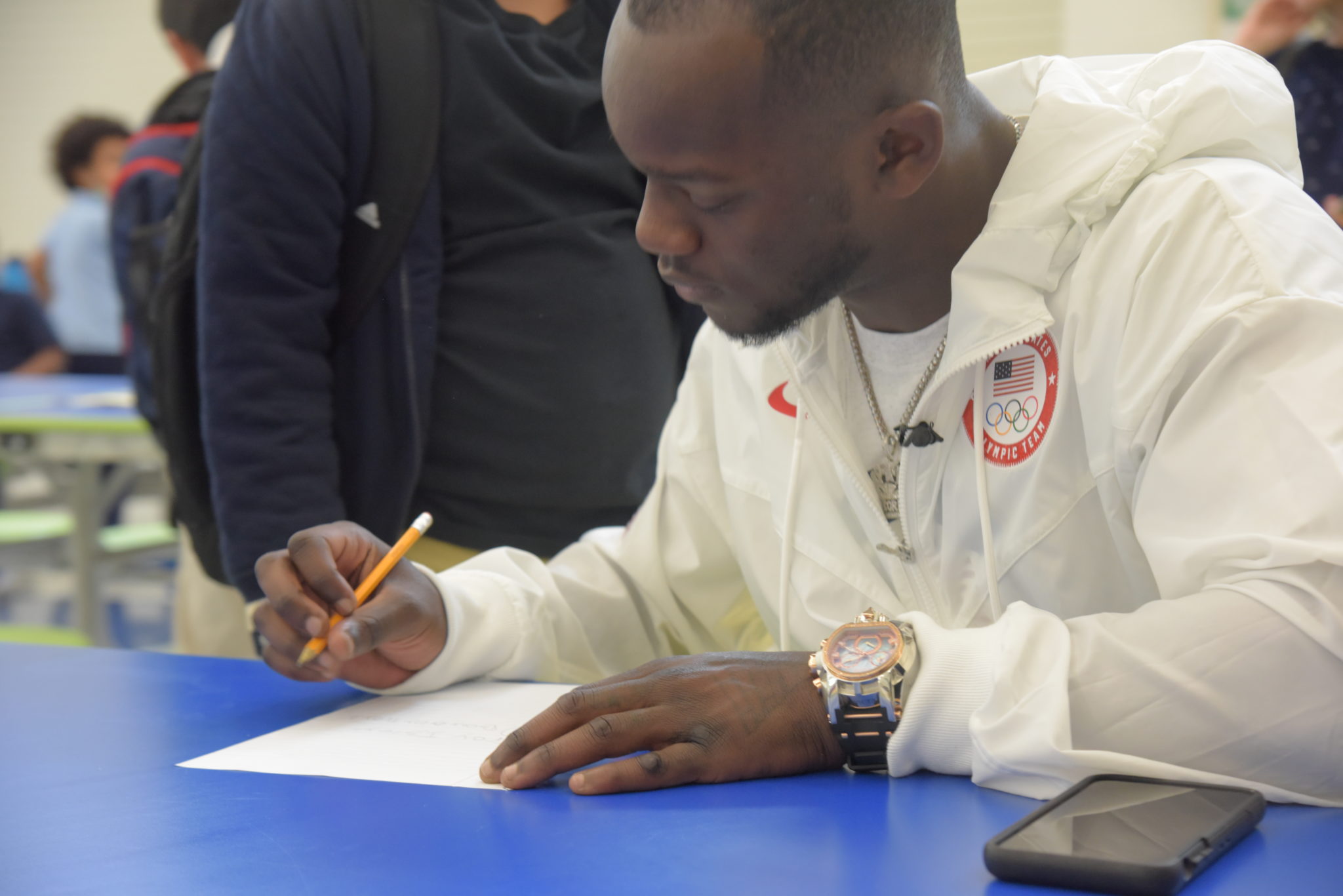 man signing autograph while student looks at him