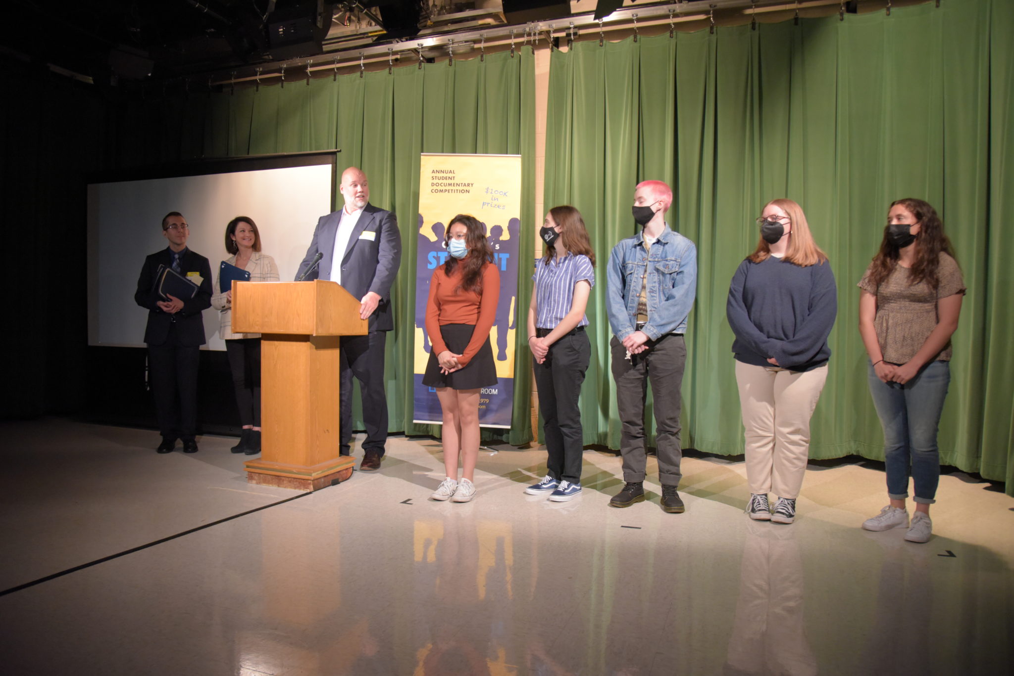 a line of people stand in a dark room 