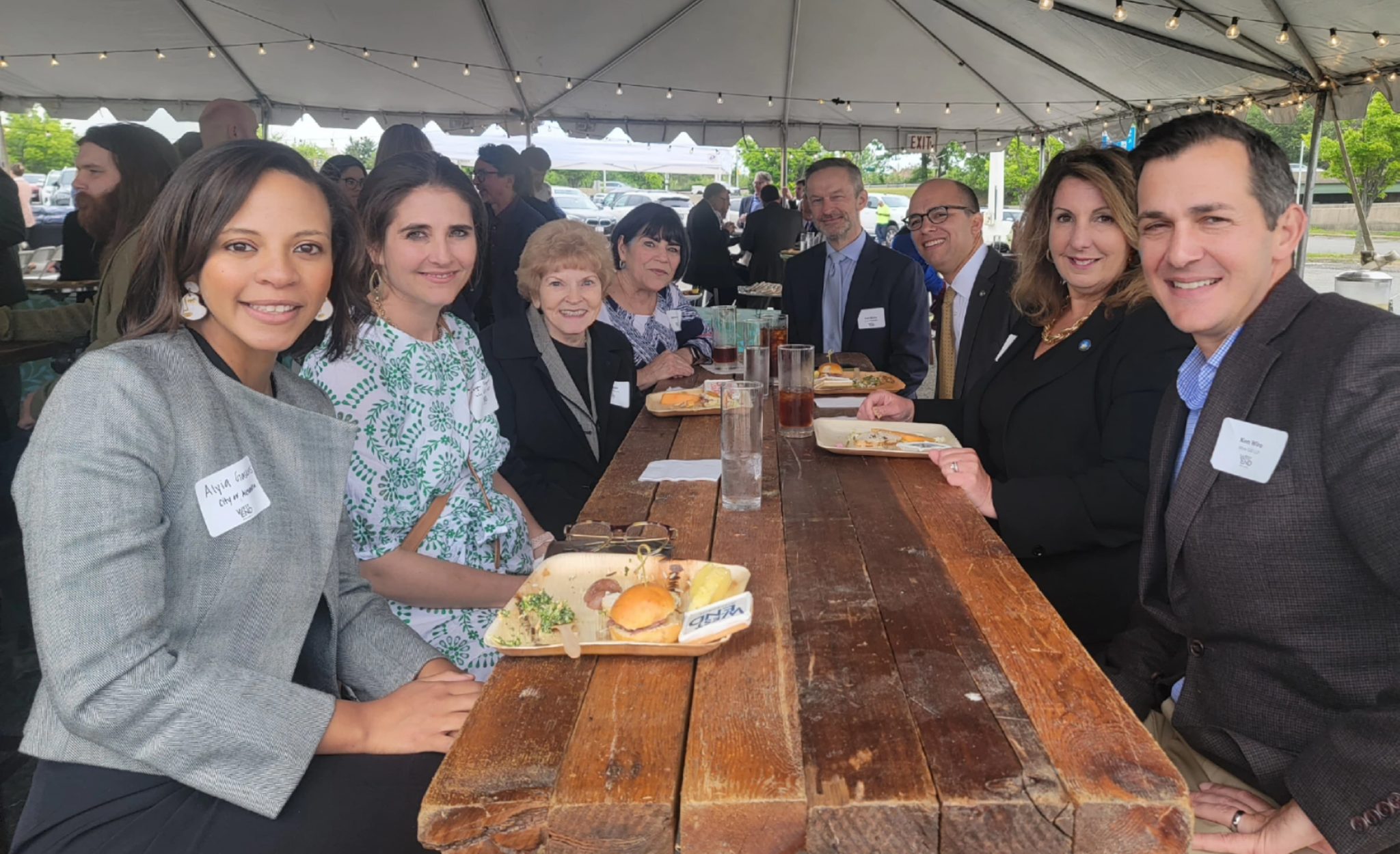 Alexandria City Council members sit at a long table and enjoy lunch