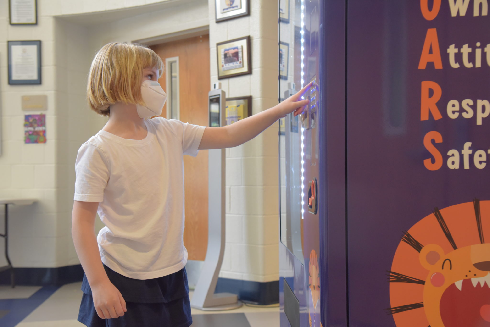 a young school girl stands in front of a vending machine with her fingers on the buttons