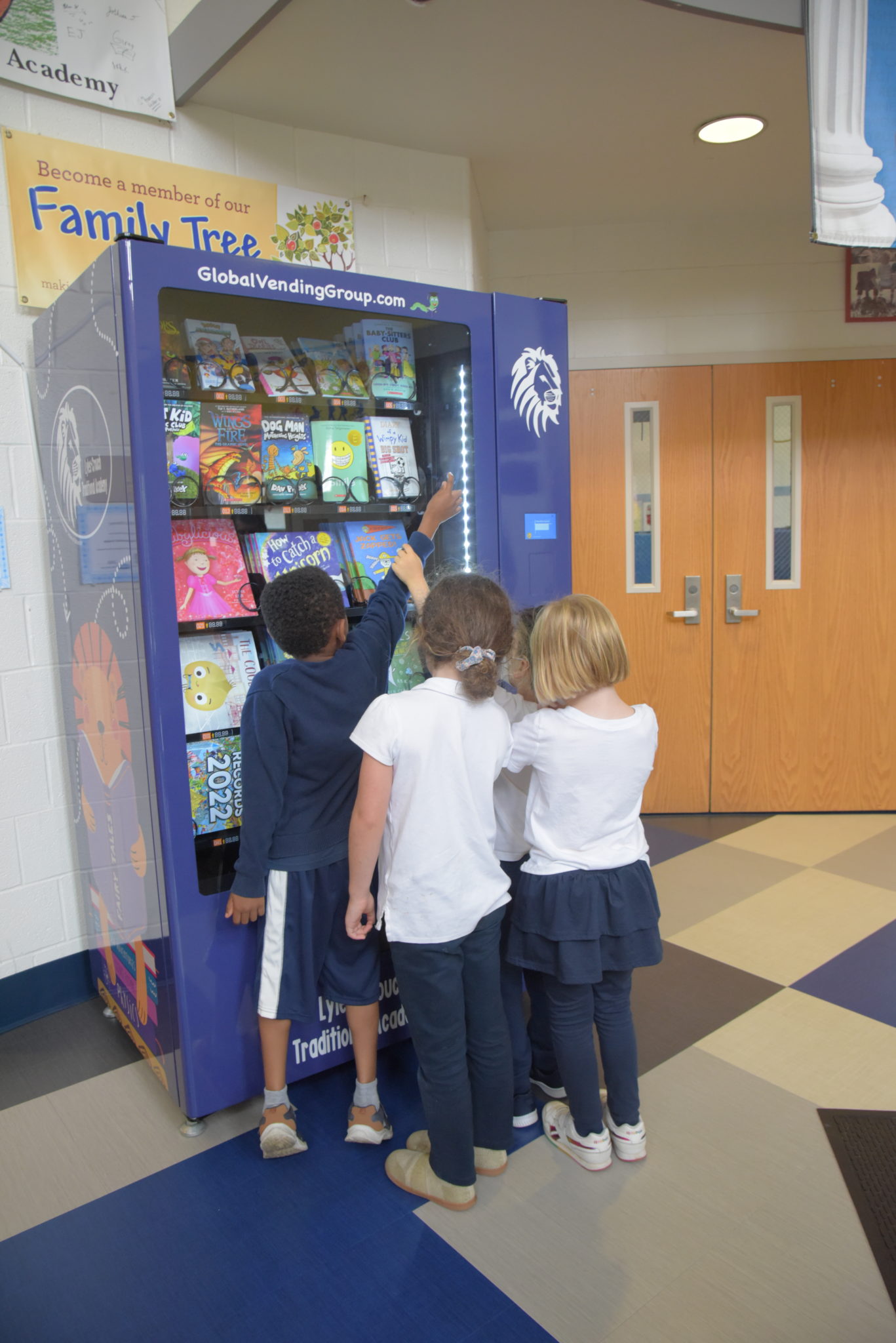 Four school children crow in front of a book vending machine to see their choices