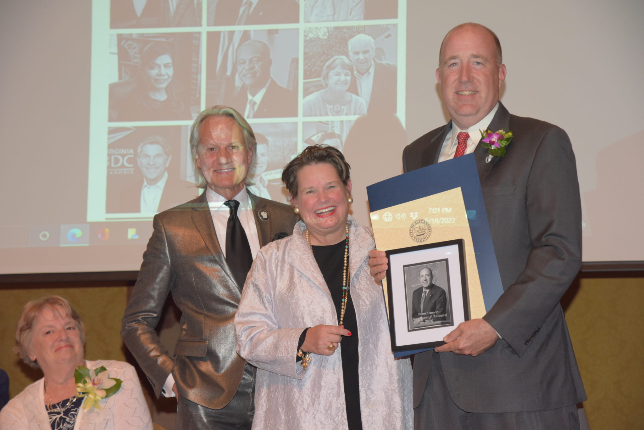 Frank Fannon IV holds photo and certificates and stands next to Mary Wadland and Monte Durham