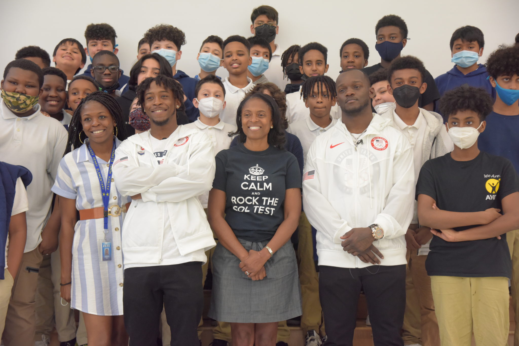 middle school students stand on stage with olympic boxers