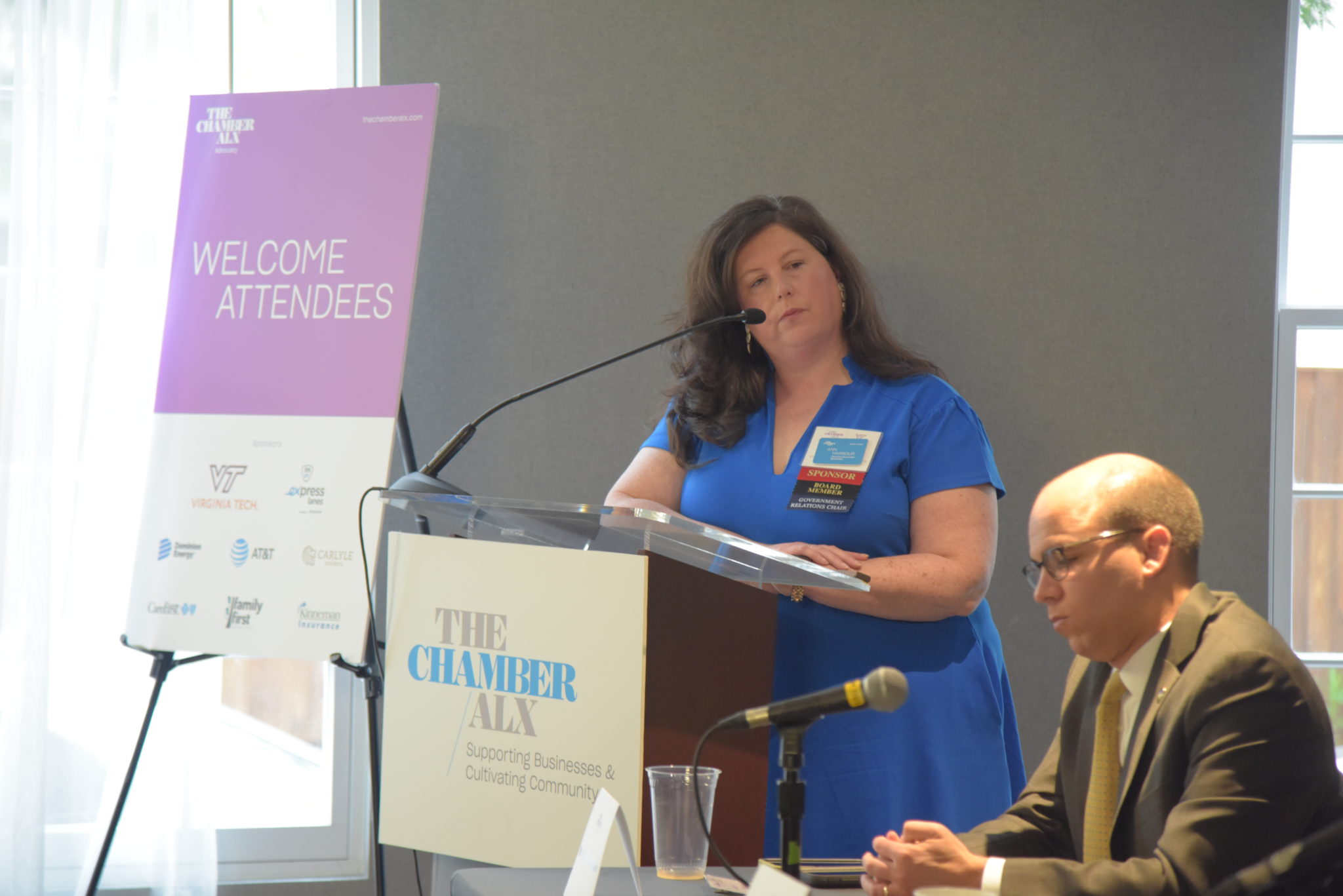 woman stands at podium in royal blue dress