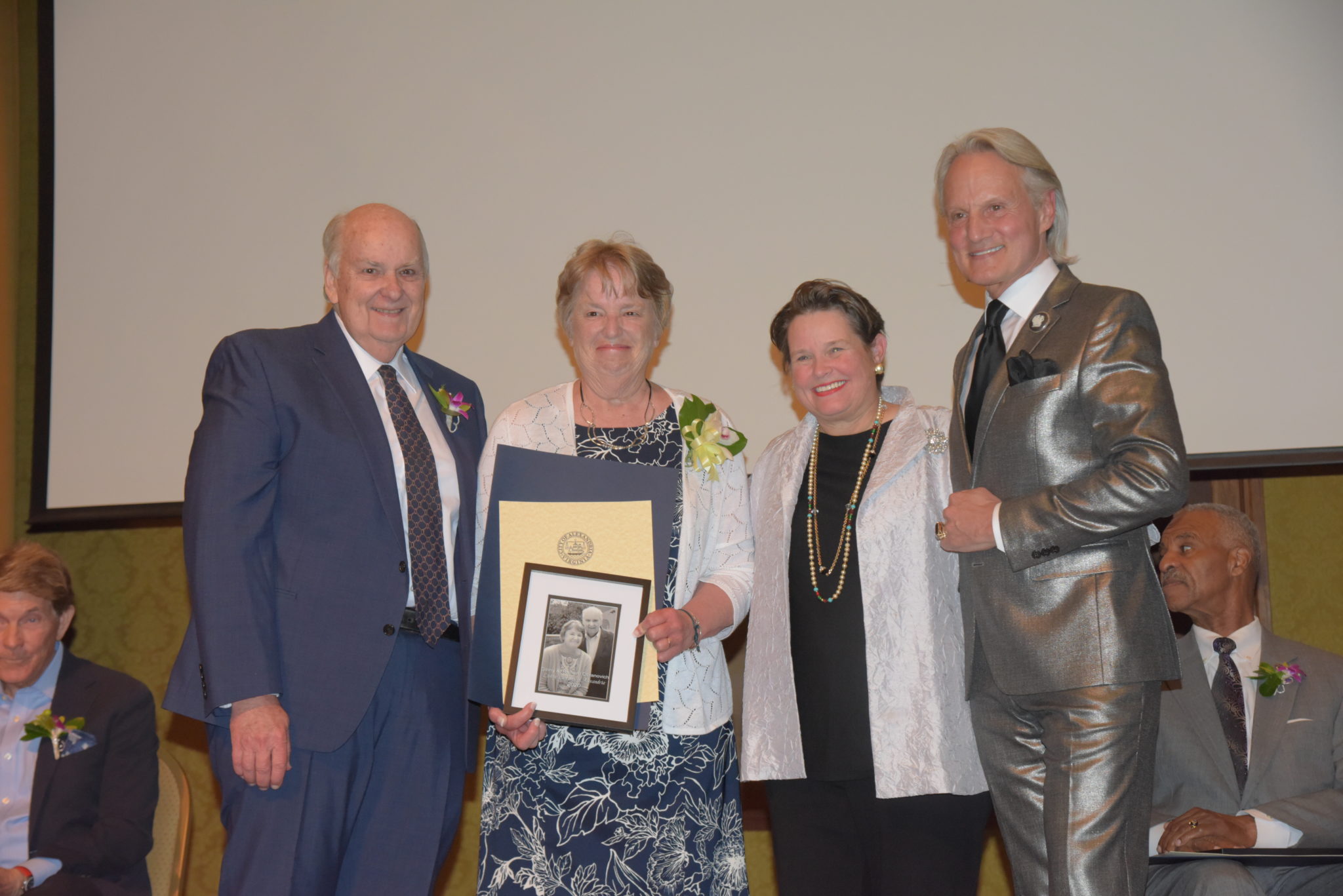 The Obranoviches hold photo and certificates and stands next to Mary Wadland and Monte Durham