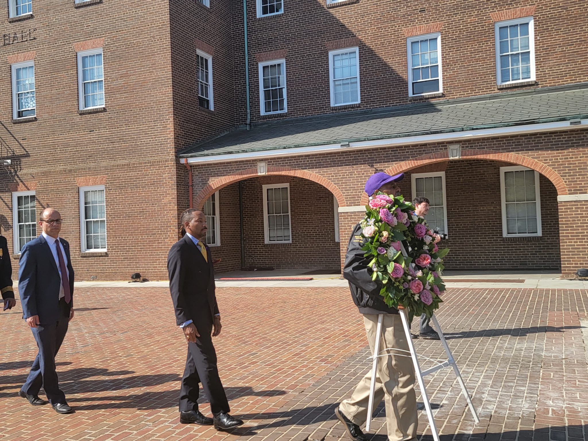 a line of people carrying wreath