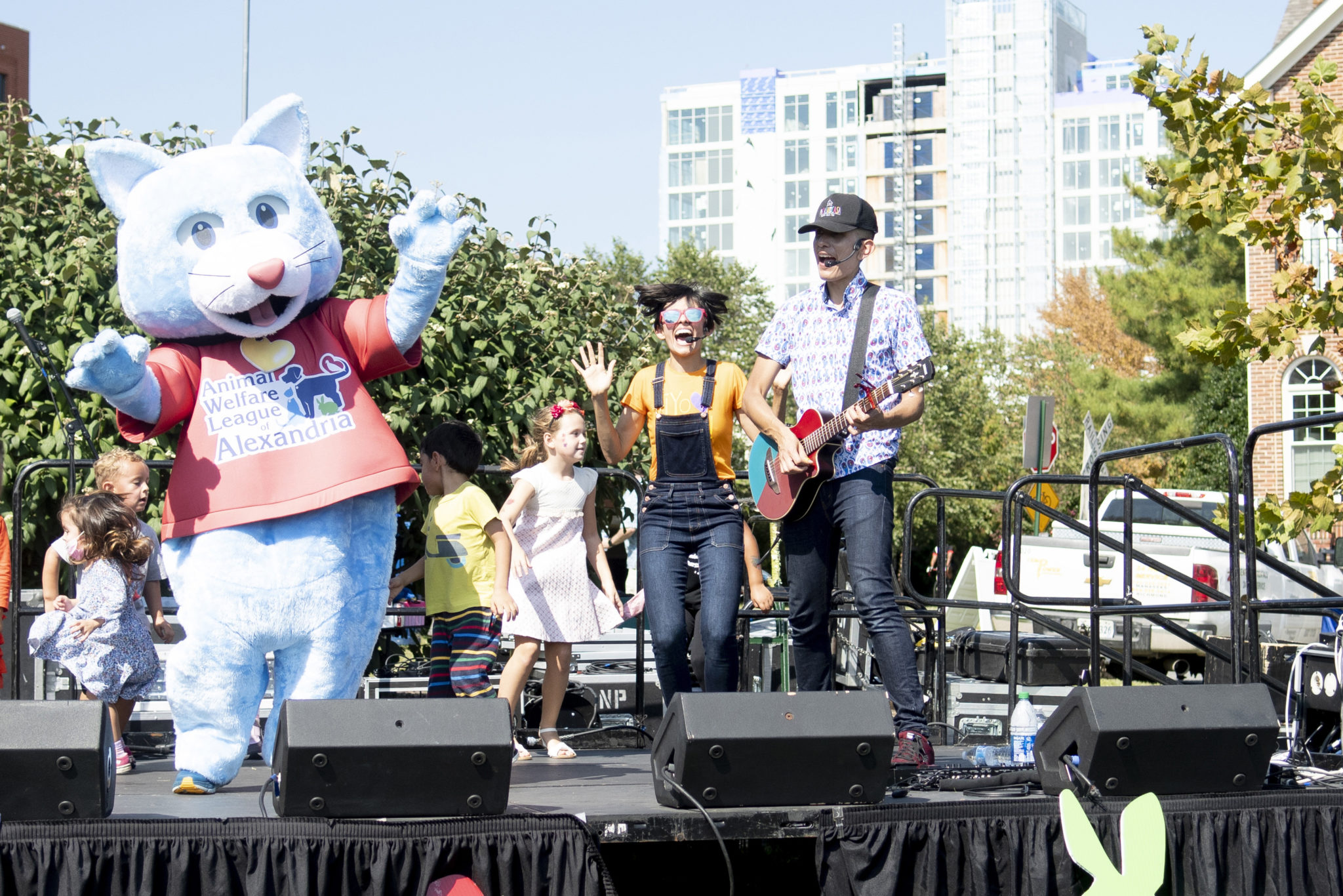 a person in a cat costume on stage with a female and male performer