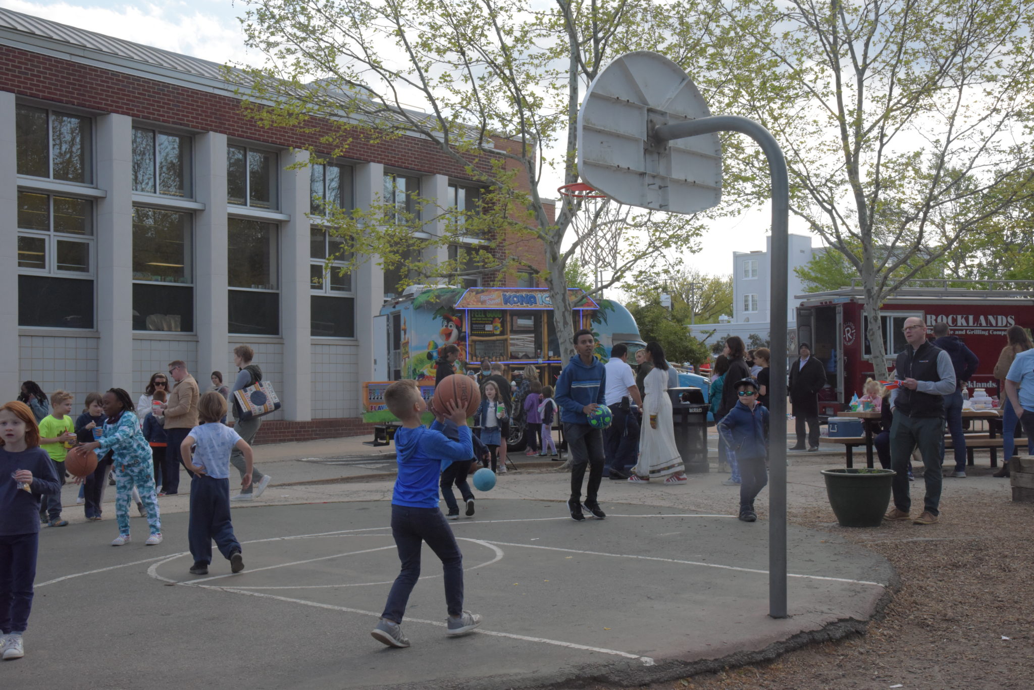 young boy throws ball into basketball hoop