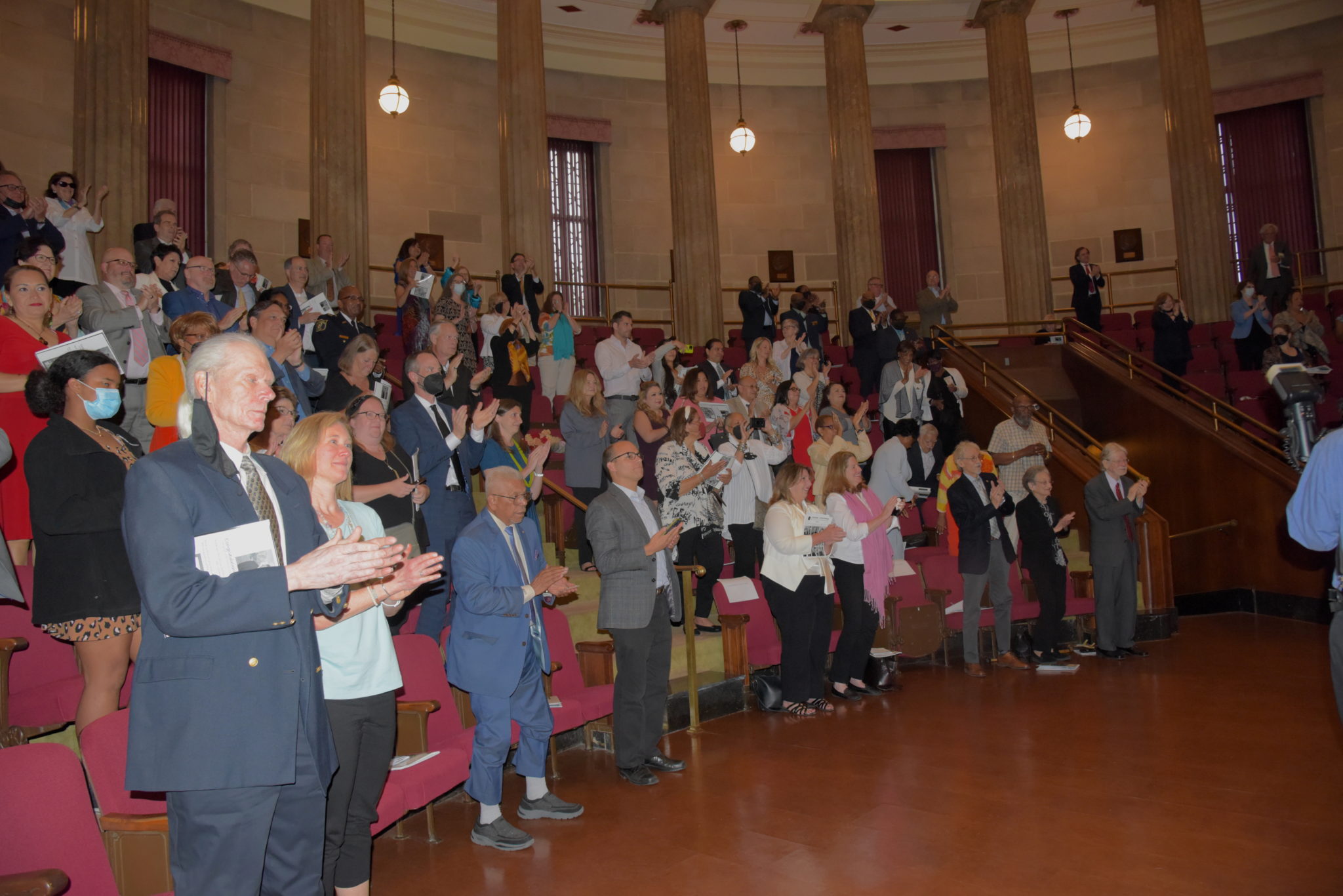 a crowd in a theater gives a standing ovation